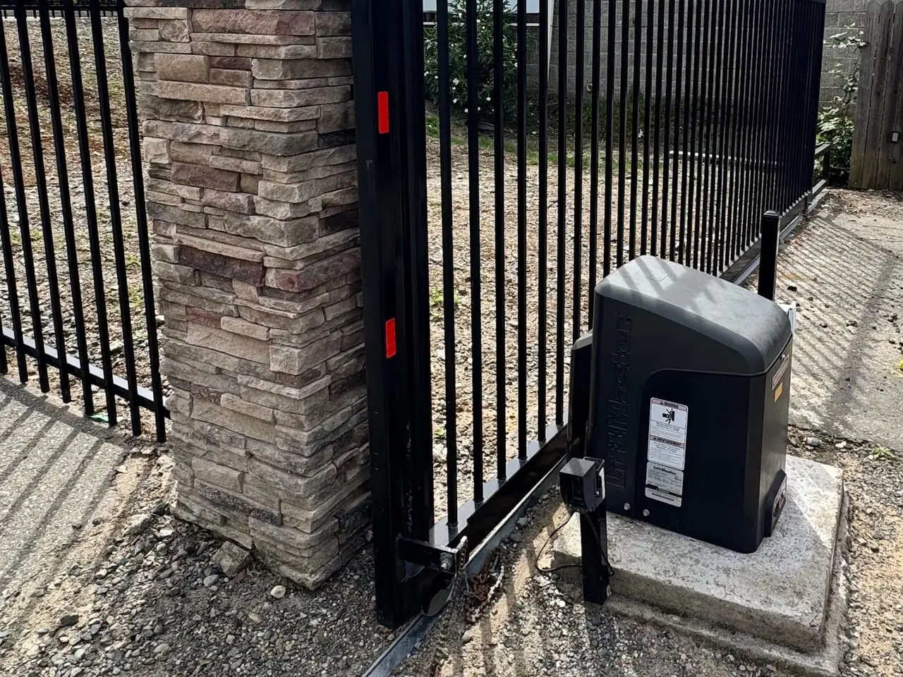 Newly installed slide gate with a LiftMaster slide operator on a fresh concrete pad, installed by LMS Garage Doors