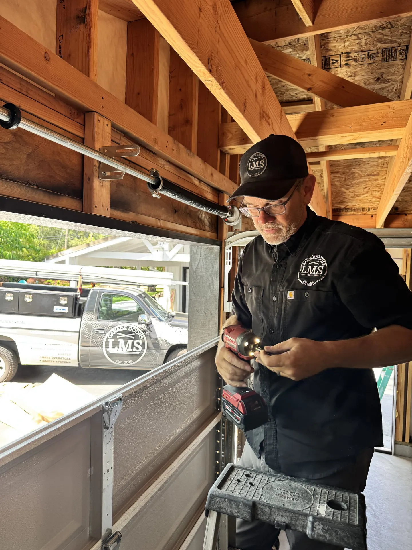 LMS technician drilling a garage door bracket