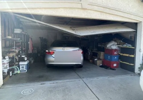 Garage door stuck half-open with car trapped inside — emergency call